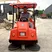 Red industrial floor sweeper operating in factory courtyard and outdoor areas